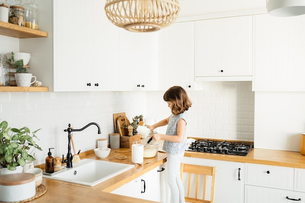 Child making pancakes for breakfast Real people home life