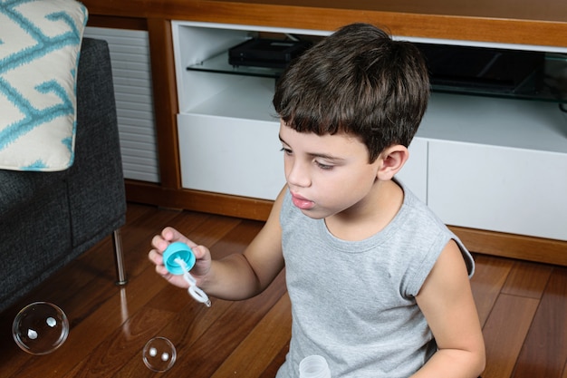 child making soap bubble at home