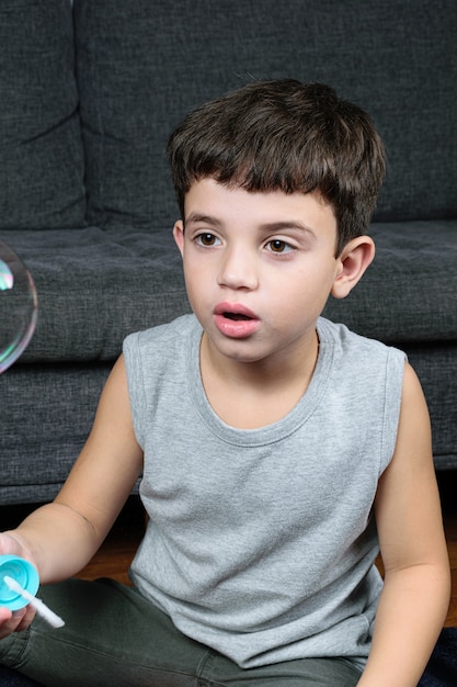 Photo child making soap bubble at home