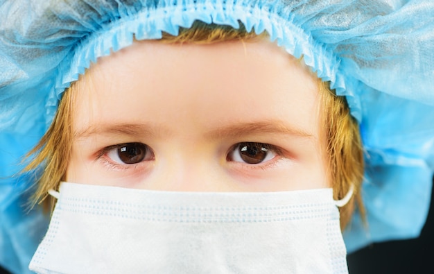 Child in mask for protection against Covid-19 coronavirus pandemic. Illness prevention. Small boy in medical cap and mask. Closeup.