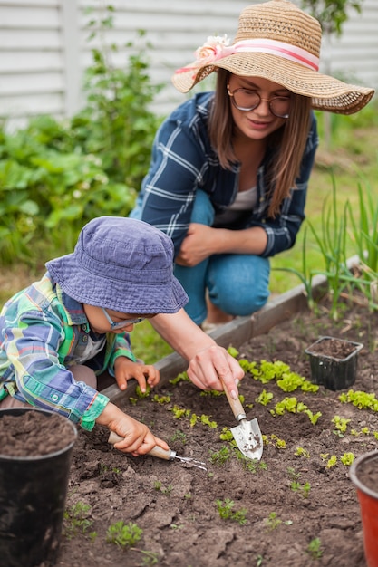 Bambino e madre giardinaggio nell'orto in cortile