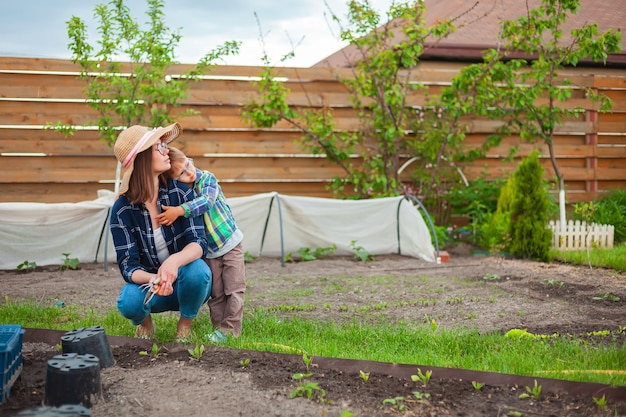 Bambino e madre che fanno giardinaggio nell'orto nel cortile