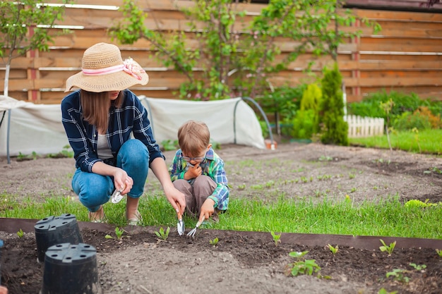 Foto bambino e madre che fanno giardinaggio nell'orto nel cortile