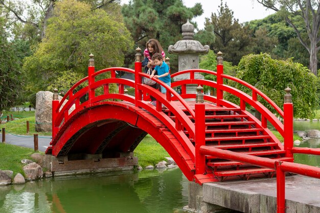 Child and mother leaning out on typical Japanese bridge