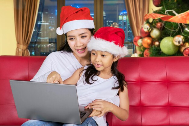 クリスマスの時期にラップトップを持つ子供と母親