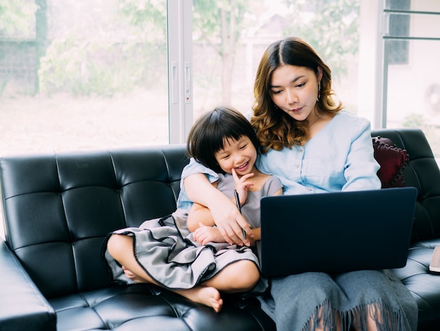 子供とお母さんがlabtopを見ていると一緒に幸せを感じる