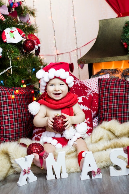 Child in New Year's clothes, spends time at the Christmas tree