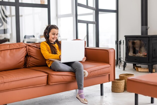 Child online. A little girl uses a laptop video chat to communicate learning while sitting at a laptop at home.