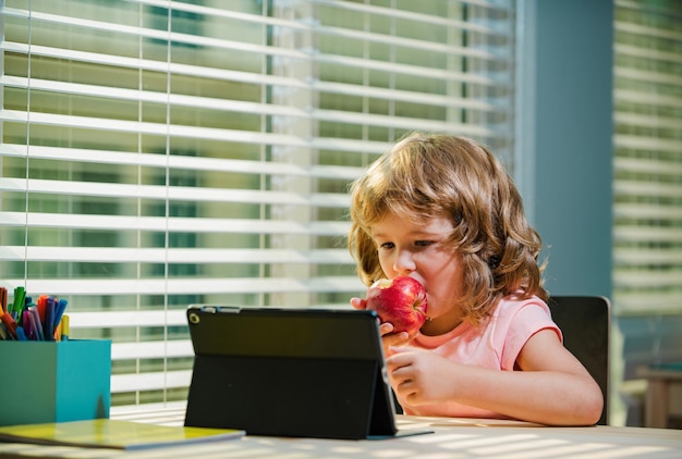 Bambino a scuola online scuola a casa focolaio di coronavirus scolaro che guarda la classe di istruzione online