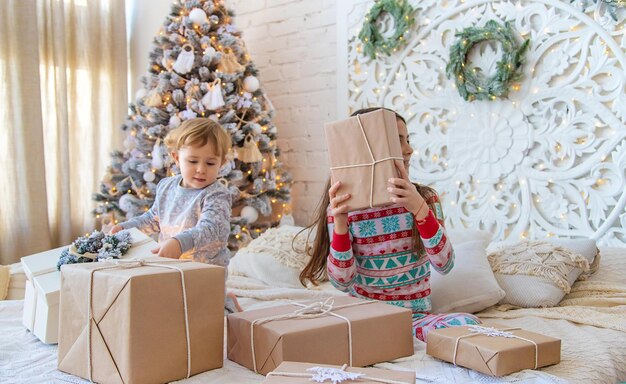 Child open Christmas gifts under the tree Selective focus