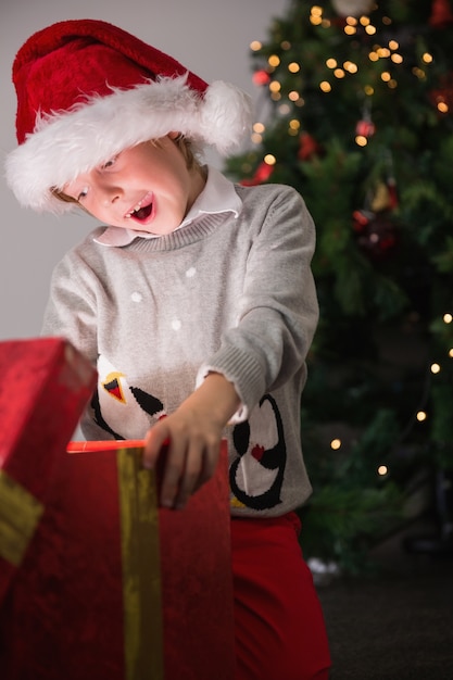 彼のクリスマスプレゼントを開いている子供