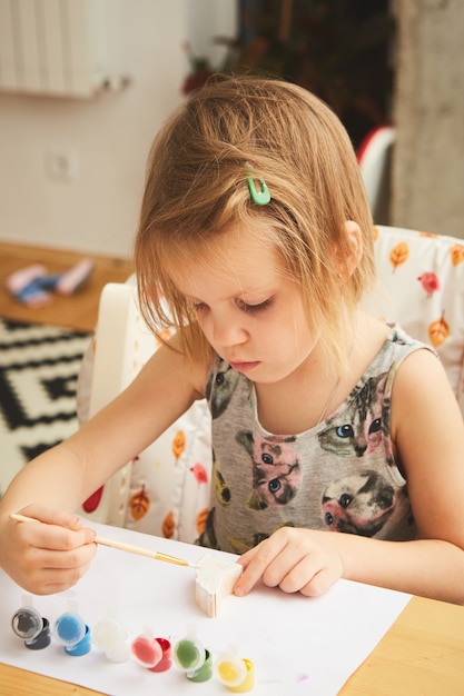 Child Painting. Happy preschool age girl holding a brush painting