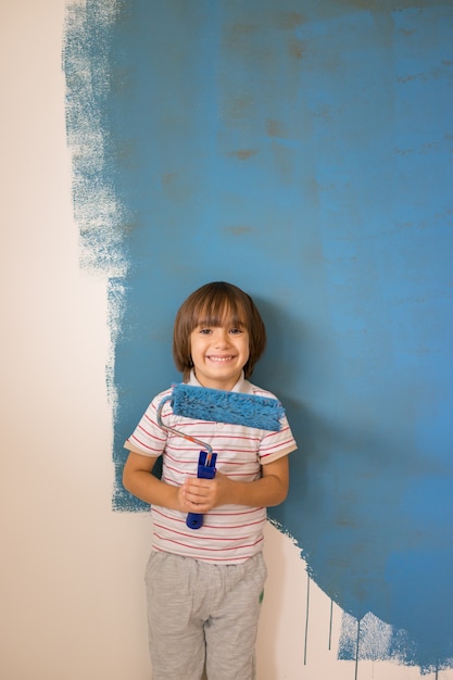 Foto bambino che dipinge la parete di casa a colori