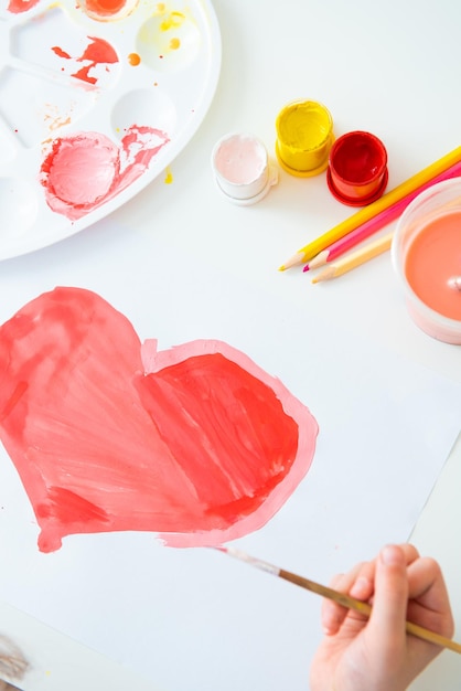 a child paints a heart to his mother for valentines day