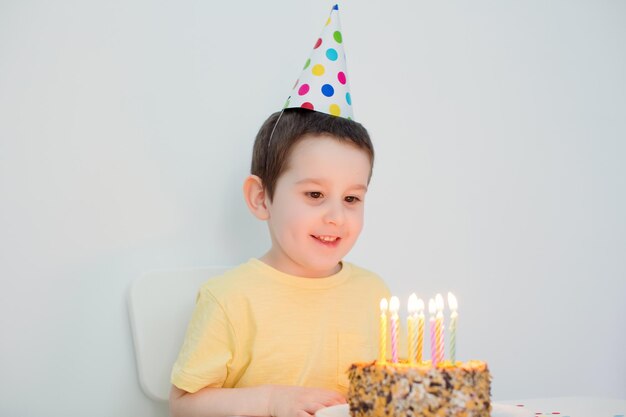 Child in party hat birthday cake