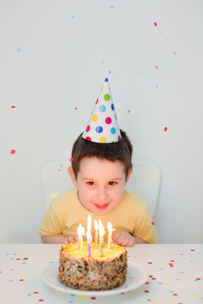 Child in party hat birthday cake