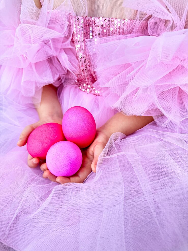 Photo child in pink tulle dress holding bright pink eggs easter celebration concept with a playful and