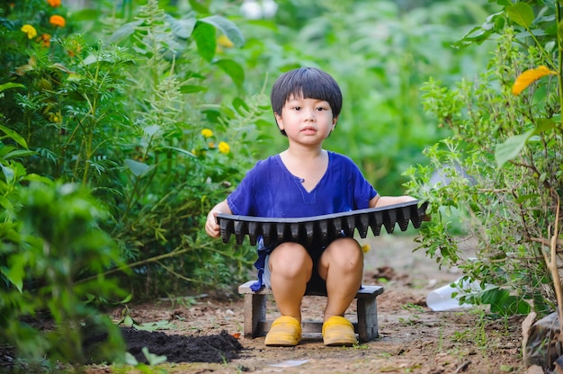 家庭での子供の学習活動のトレイの概念で野菜を植える子供