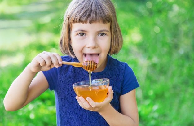 Child a plate of honey in the hands