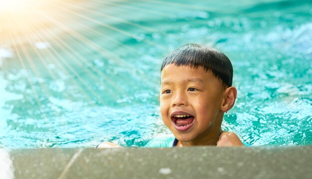 child play in water swimming pool with fun and joy happiness in summer with smiling and enjoyment