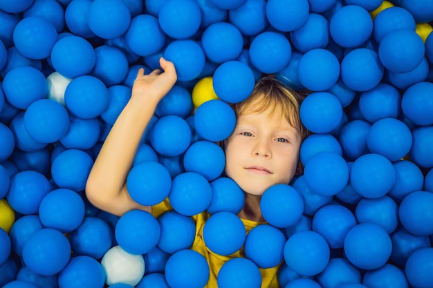 Bambini che giocano nella vasca delle palline giocattoli colorati per bambini scuola materna o scuola materna sala giochi bambino del bambino al parco giochi al coperto piscina di palline per bambini festa di compleanno per bambini in età prescolare attivi