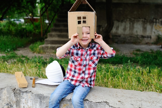 Child playing in a cardboard toy house