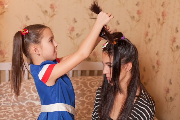 Child playing hairdresser with mother.