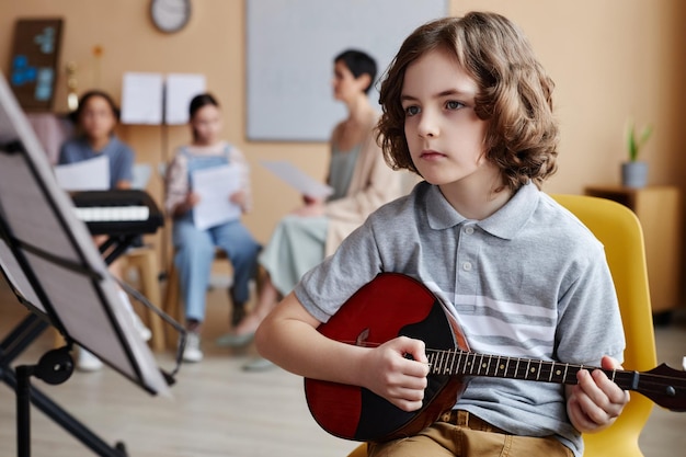 Foto bambino che suona uno strumento musicale in classe