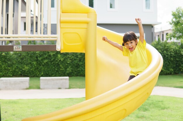 Photo child playing on outdoor playground kids play on school or kindergarten yard active kid on colorful slide and swing healthy summer activity for children