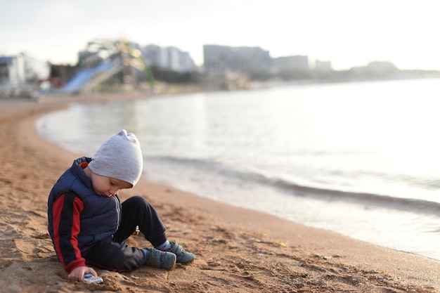 A child playing in the sand by the sea