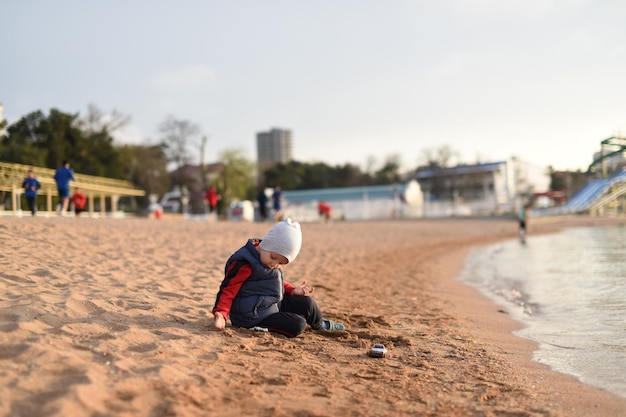 A child playing in the sand by the sea