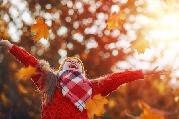 Child playing with autumn leaves