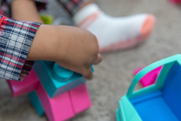 Child playing with bricks at home to construct a toy