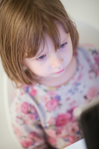 child playing with digital tablet at home