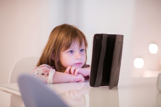 child playing with digital tablet at home