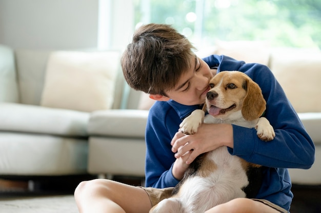 家でペットの犬と遊ぶ子供。