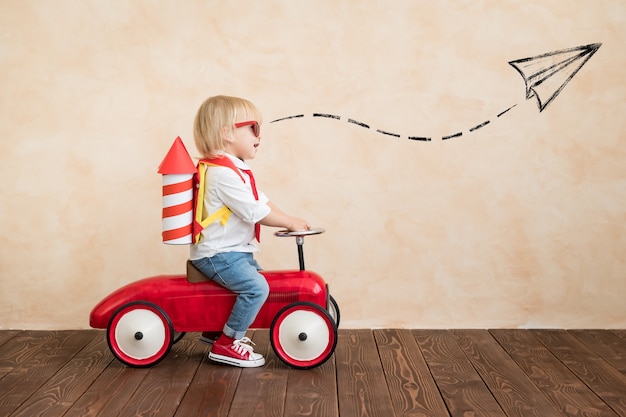 Child playing with paper rocket