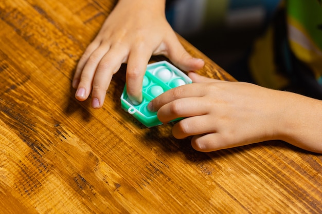 Child playing with pop itpressing the bubbles with his fingerstop viewnew antistress toy for childre...