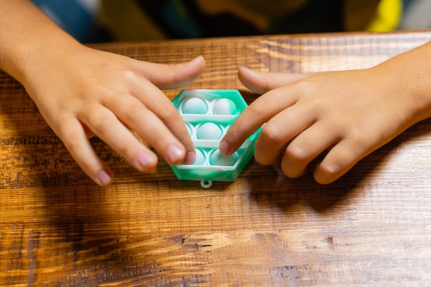 Child playing with pop itpressing the bubbles with his fingerstop viewnew antistress toy for childre...