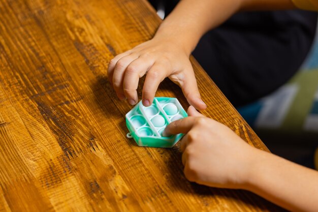 Child playing with pop itpressing the bubbles with his fingerstop viewnew antistress toy for childre...