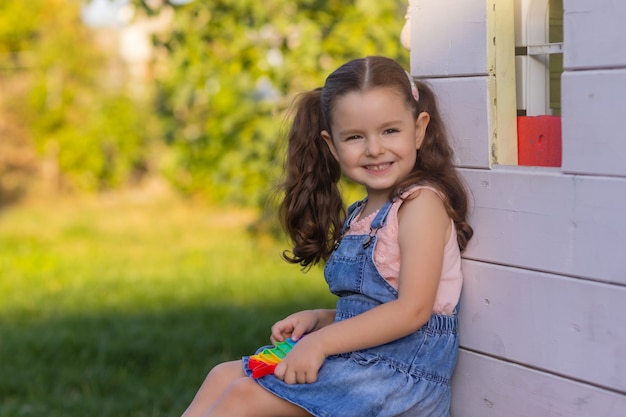 指止めで泡を押してポップで遊んでいる子供は、子供のための新しい抗ストレスおもちゃを表示します...