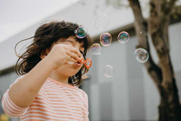 Foto bambino che gioca con le bolle di sapone