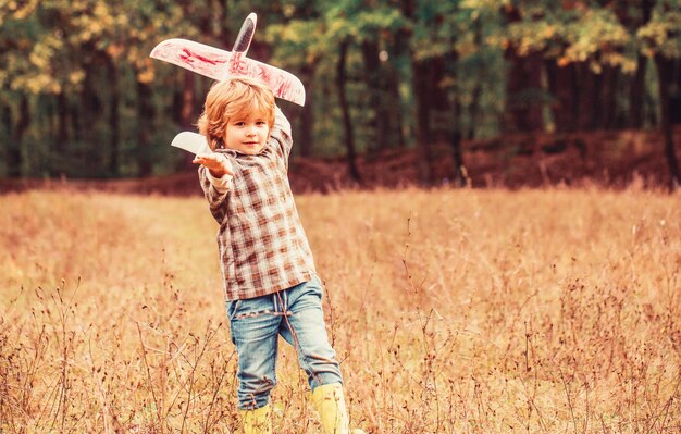 Child playing with toy airplane Happy child playing outdoors Happy boy play airplane Little boy with plane