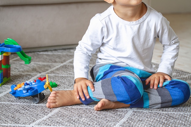 Child playing with toy blocks sitting on the floor