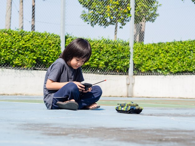 Child playing with toy tank, lifestyle for kids concept.