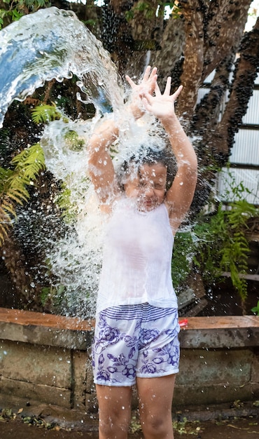 Ребенок играет во дворе с водой бразильским летом