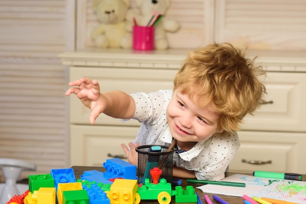 プレイルームの子供。子供たちの顔、カラフルなブロックで遊ぶ男の子、肖像画。