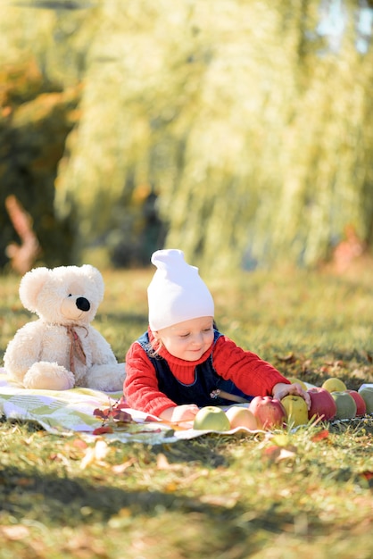 Il bambino gioca nella foresta d'autunno con mele e matite. tema autunnale
