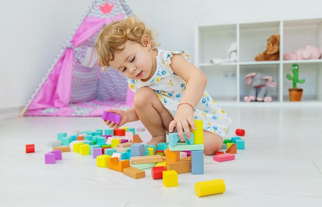 The child plays in the children's room with a wooden constructor Selective focus