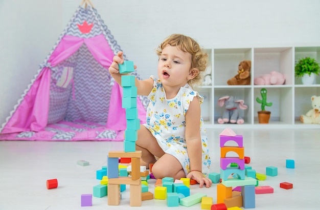 The child plays in the children's room with a wooden constructor Selective focus